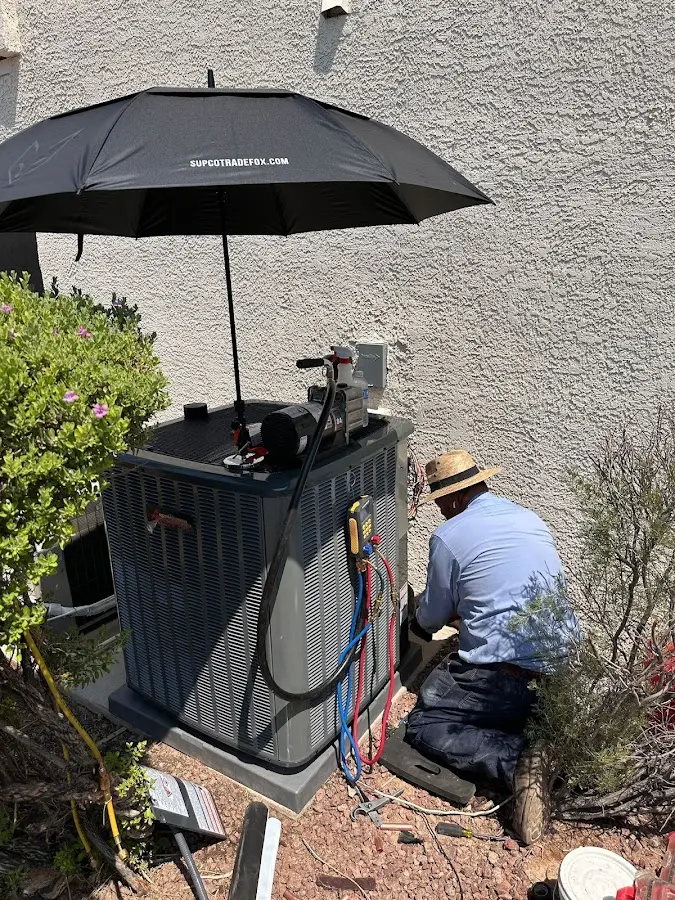 HVAC technician performing outdoor AC maintenance in Frederickson