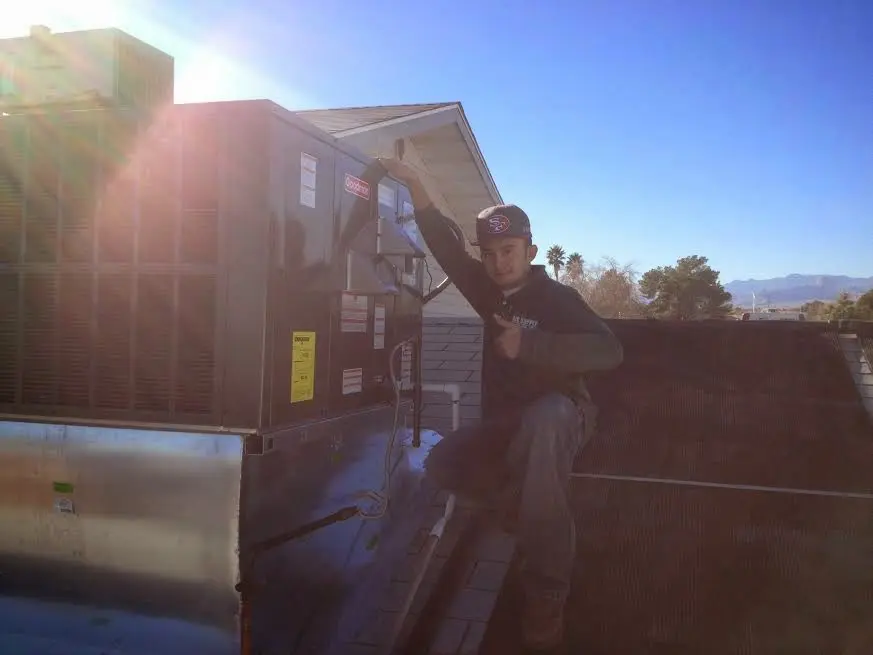 HVAC technician performing HVAC Inspection on a rooftop unit in Frederickson